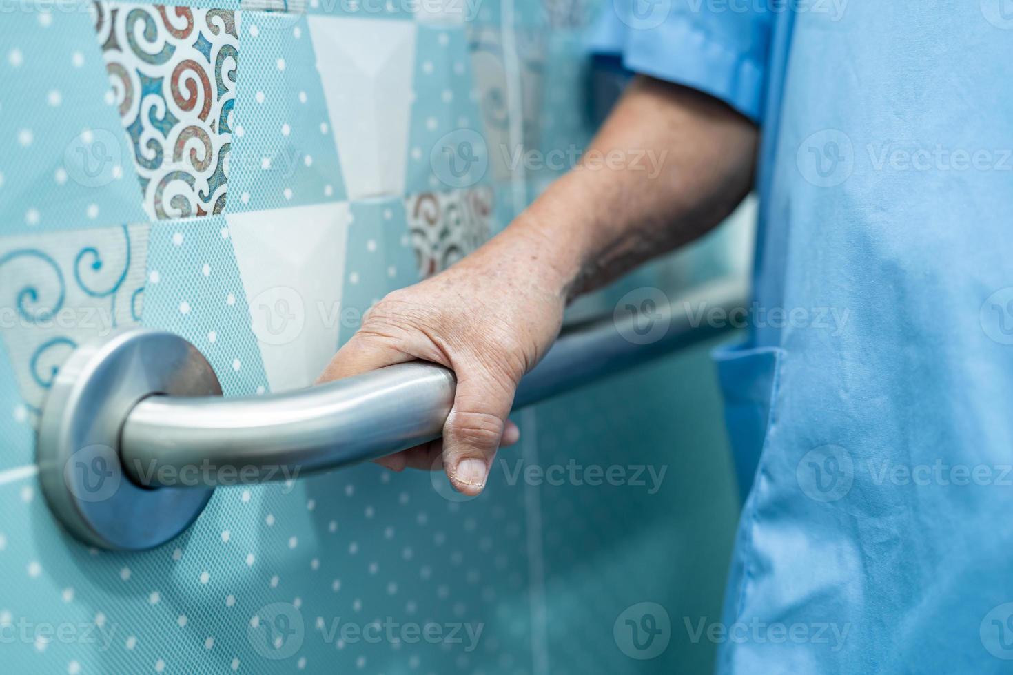 Une patiente asiatique âgée ou âgée utilise la sécurité de la poignée de la salle de bain des toilettes dans la salle d'hôpital de soins infirmiers, concept médical solide et sain. photo