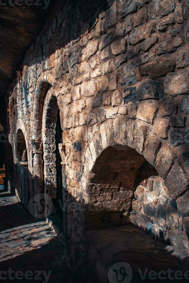 vieux brique mur niches dans église photo. noir porte de premier plan dans ancien église la photographie. sant miquel del fai monastère photo