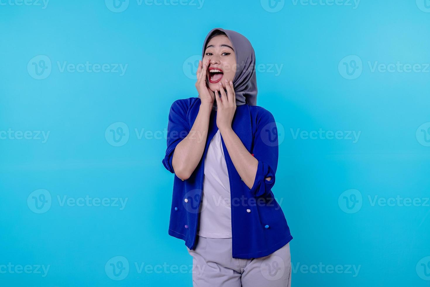 une jeune femme choquée et étonnée portant le hijab en criant de secouer la couverture avec les mains photo