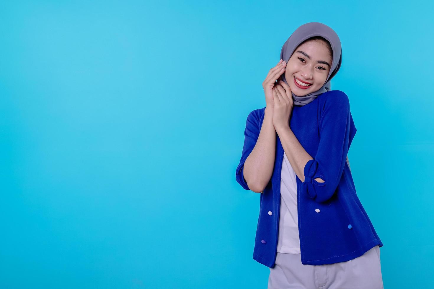 Jeune femme séduisante et charmante optimiste avec un joli sourire joyeux avec un joli sourire blanc sur fond bleu clair photo