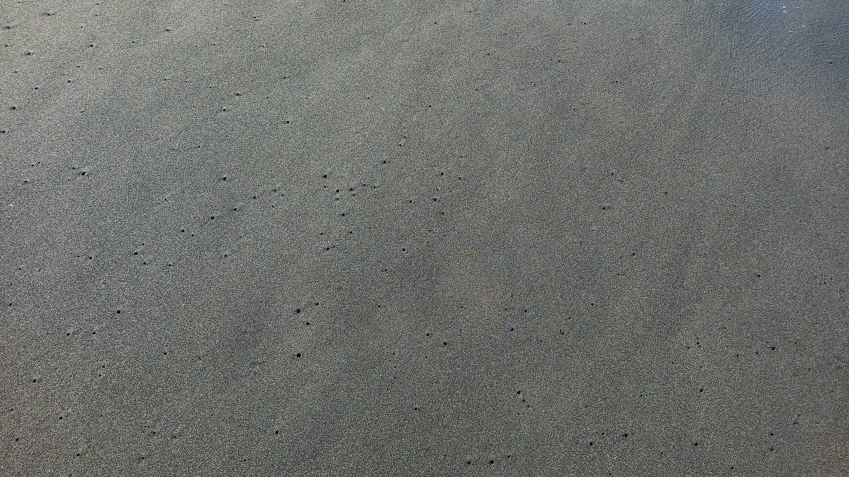 gris plage sable. doux texturé le sable surface forme haute angle. photo