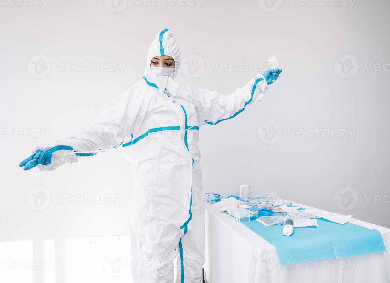 médecin en masque et costume de protection à l'aide d'un compte-gouttes à l'hôpital photo