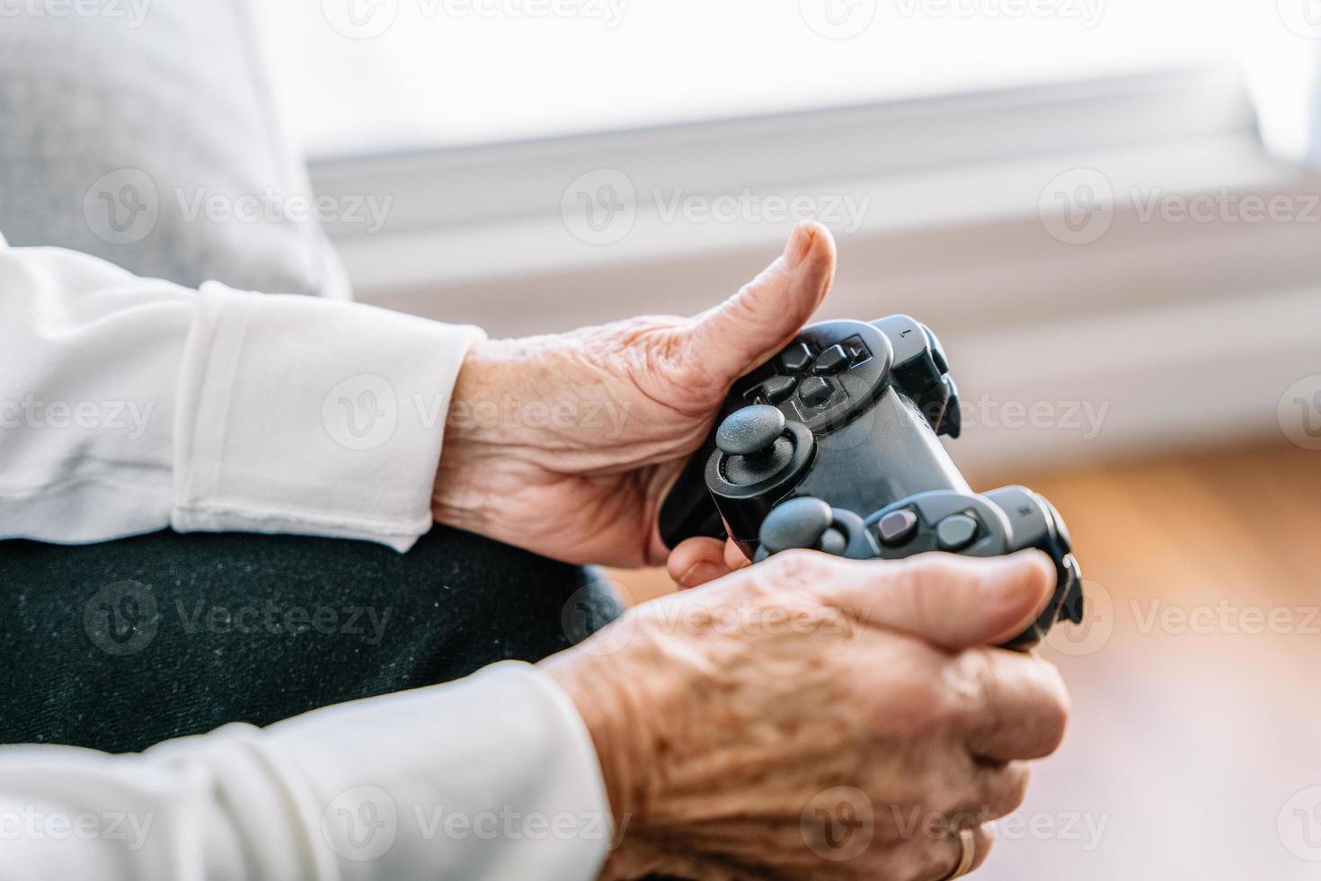 recadrer une femme âgée avec une manette de jeu à la maison photo