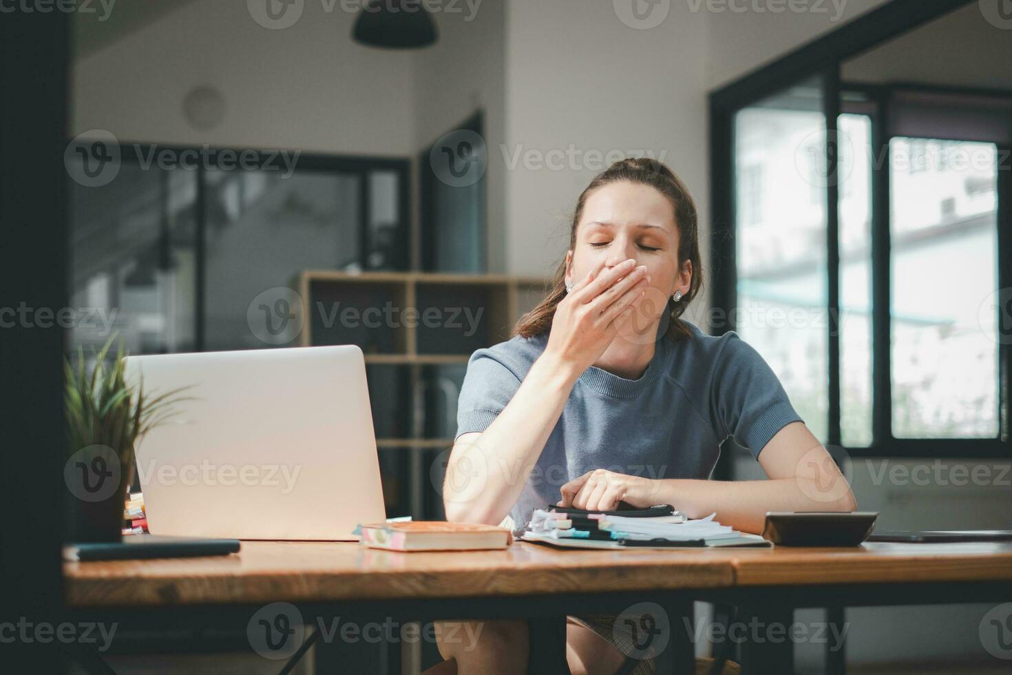 ennuyé femme d'affaires bâillement à lieu de travail sentiment non motivation ou manquer de de sommeil fatigué de ennuyeuse Bureau routine. photo