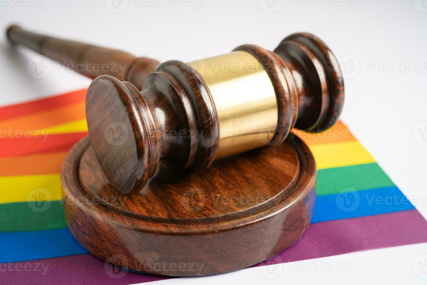 marteau pour juge avocat sur le drapeau arc-en-ciel, symbole du mois de la fierté lgbt célébrant chaque année en juin les droits des homosexuels, lesbiennes, bisexuels, transgenres et humains. photo