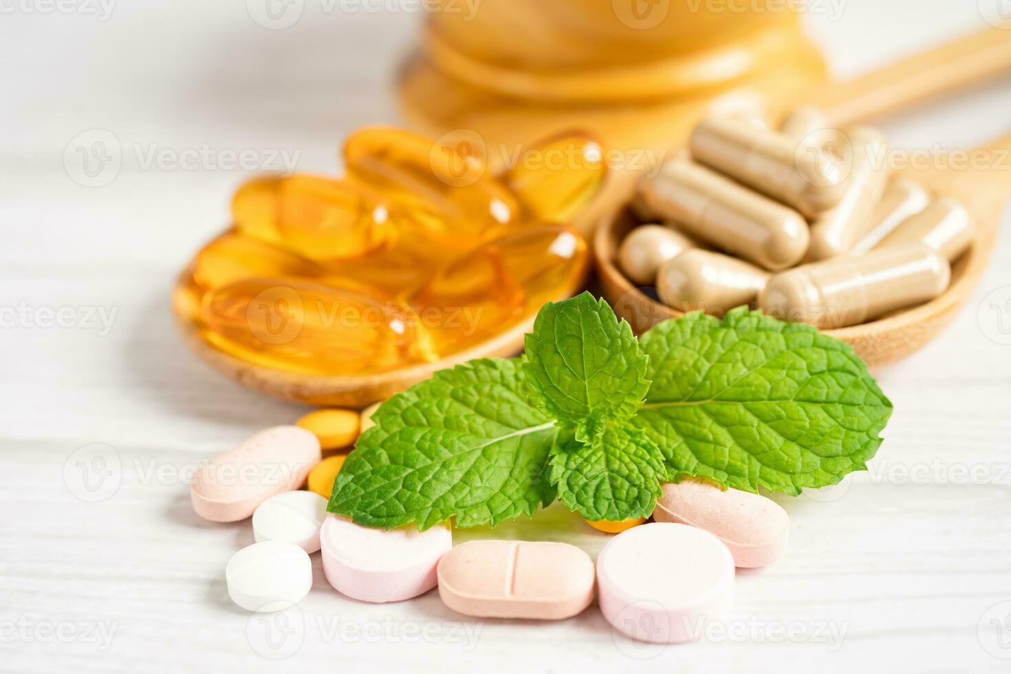 capsule biologique à base de plantes de médecine alternative avec vitamine e oméga 3 huile de poisson, minéral, médicament avec feuilles d'herbes suppléments naturels pour une bonne vie saine. photo