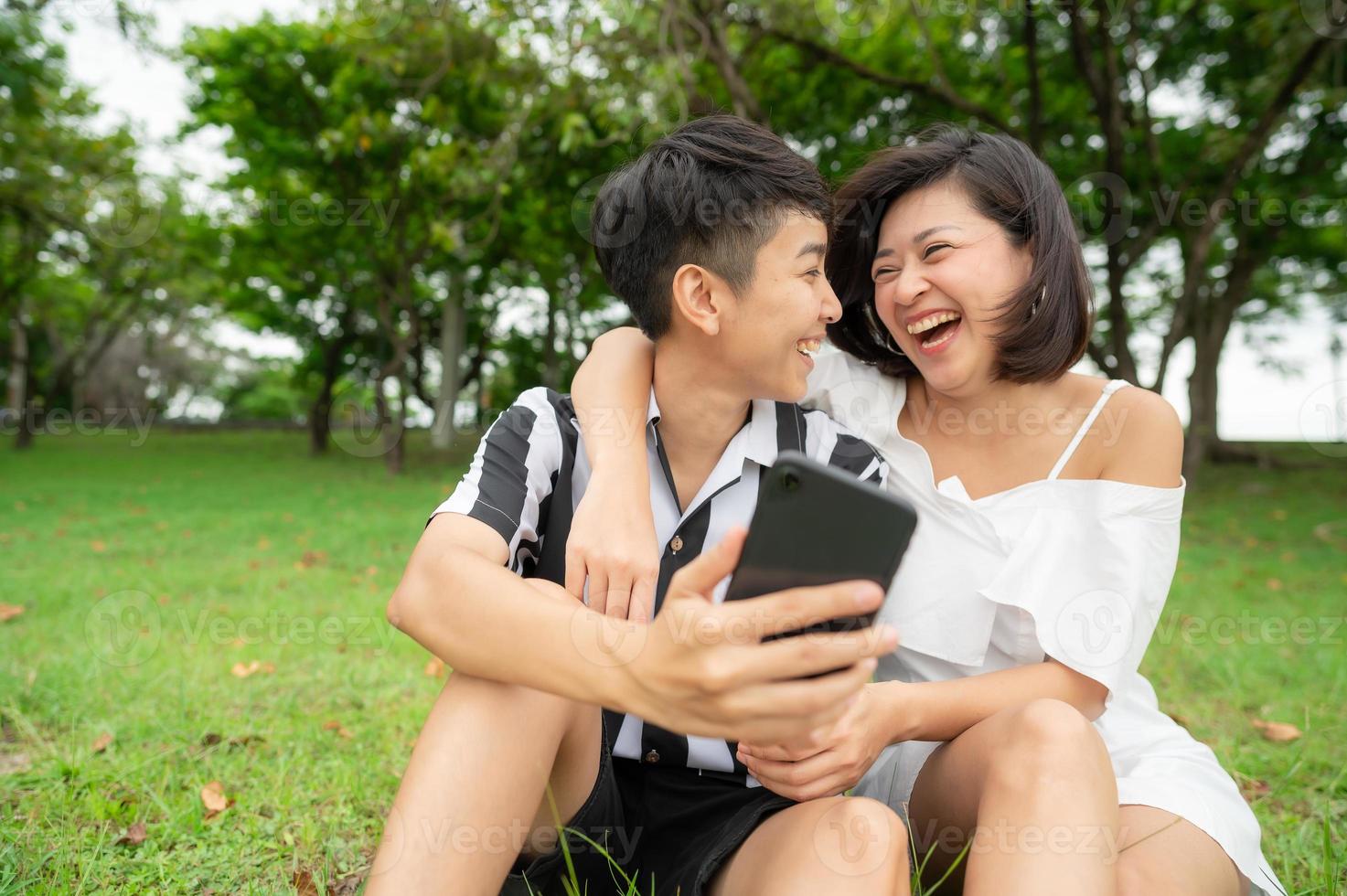 heureux couple de lesbiennes utilisant un téléphone portable en plein air photo