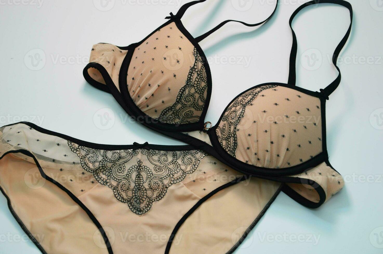 lingerie. ensemble - beige sexy culotte avec noir dentelle et une soutien-gorge sur une blanc Contexte. à la mode aux femmes sous-vêtements concept. photo