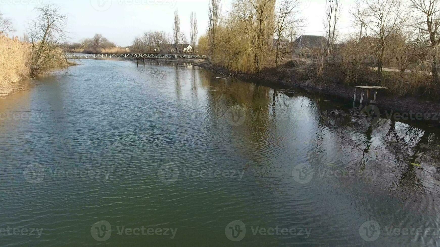 rivière Éric courant dans le village dans le printemps. peu profond rivière, lentement écoulement dans le village. photo