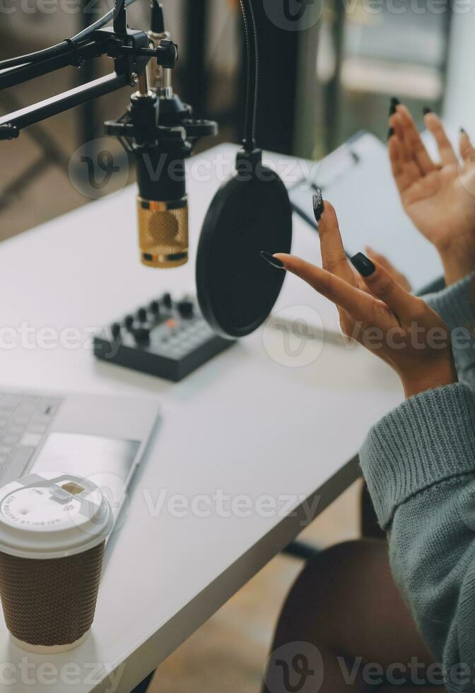 femme enregistrant un podcast sur son ordinateur portable avec un casque et un microscope. podcasteuse réalisant un podcast audio depuis son home studio. photo