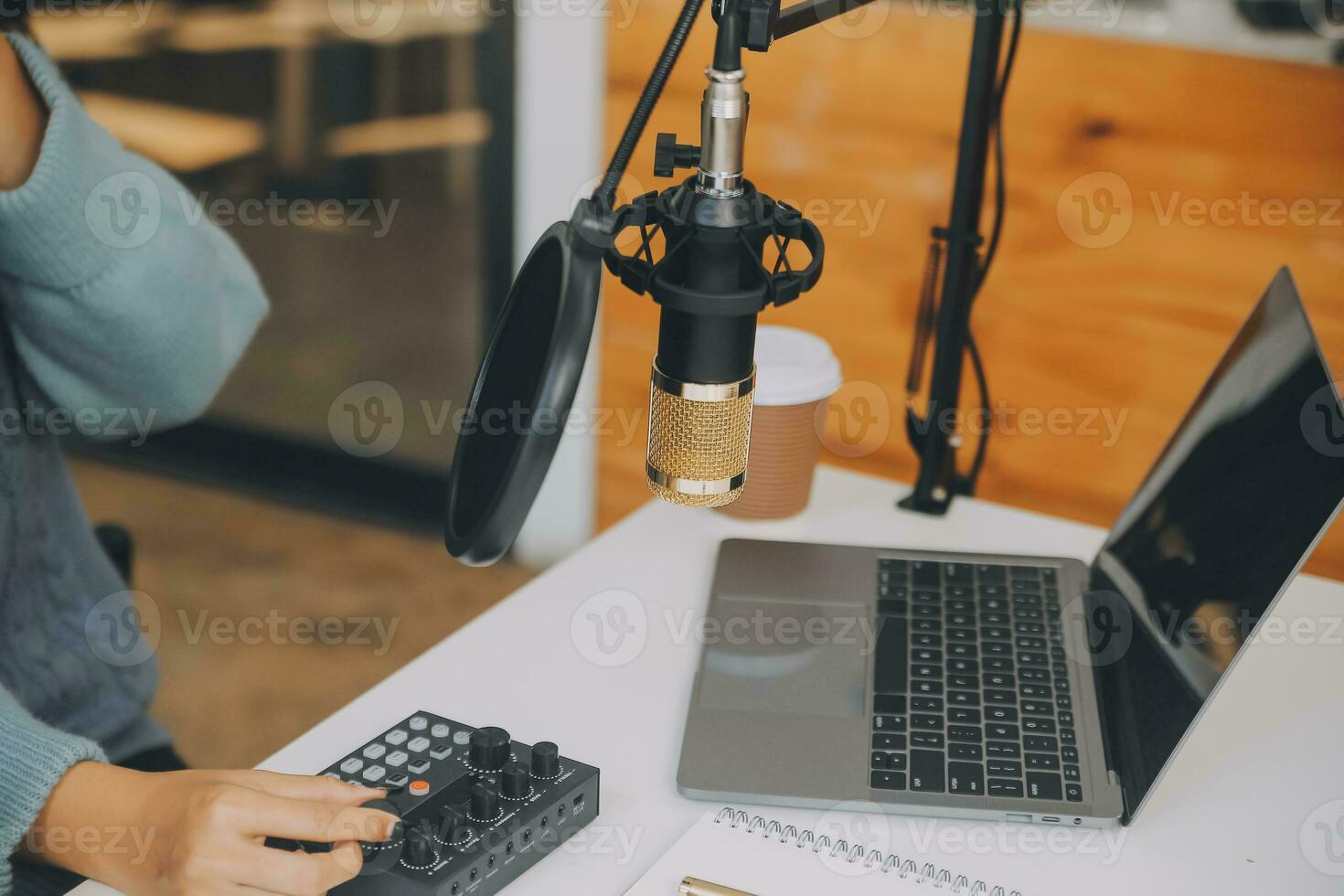 femme enregistrant un podcast sur son ordinateur portable avec un casque et un microscope. podcasteuse réalisant un podcast audio depuis son home studio. photo