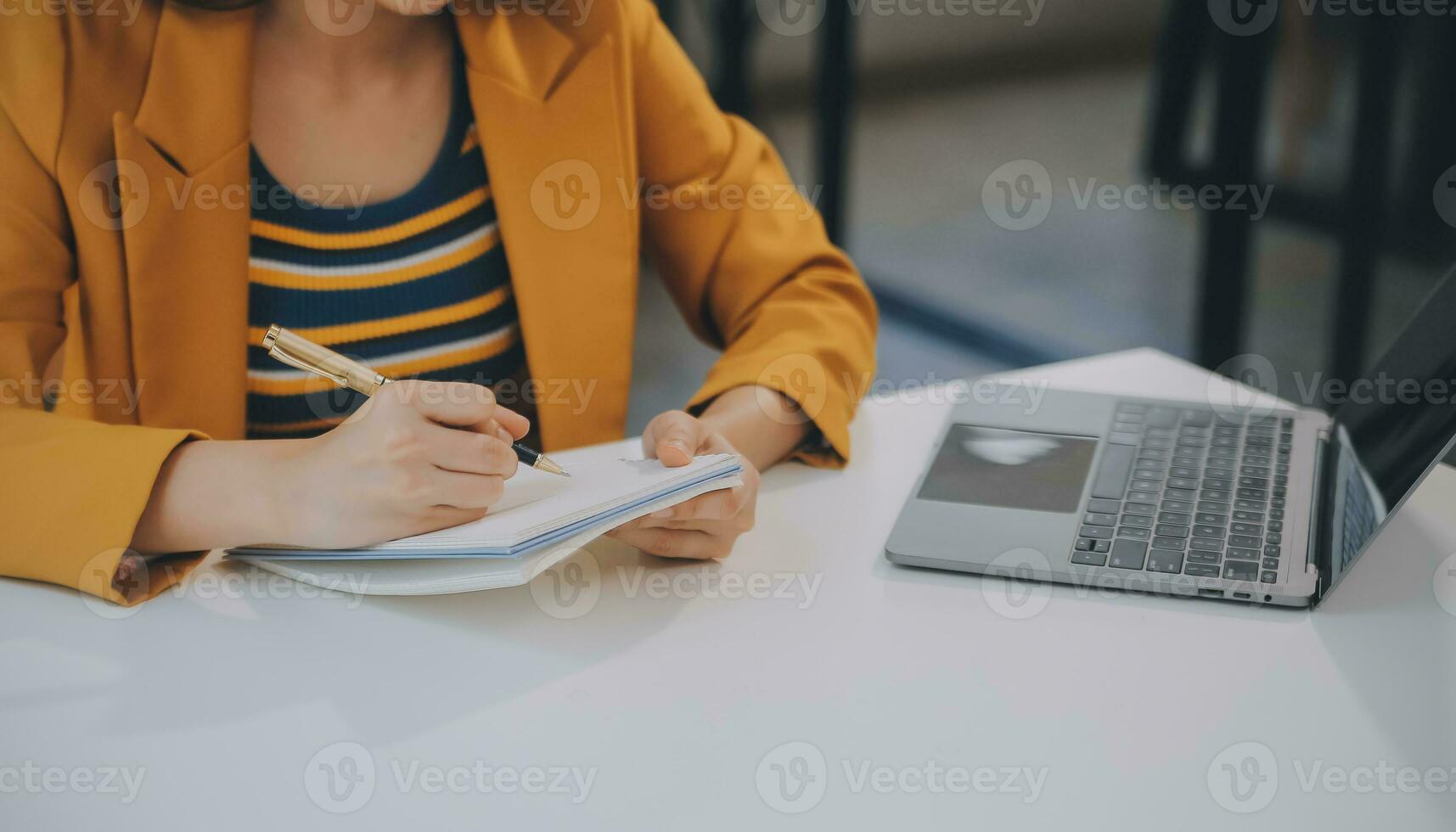 charmante jeune femme d'affaires asiatique assise sur un ordinateur portable au bureau, faisant un rapport calculant le document de vérification du service des recettes internes. photo