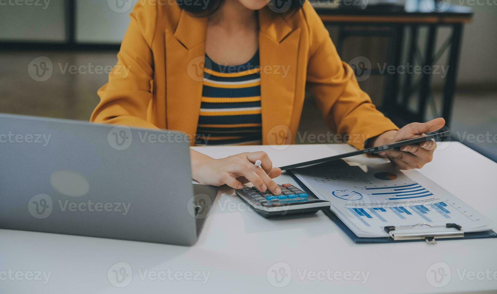 charmante jeune femme d'affaires asiatique assise sur un ordinateur portable au bureau, faisant un rapport calculant le document de vérification du service des recettes internes. photo
