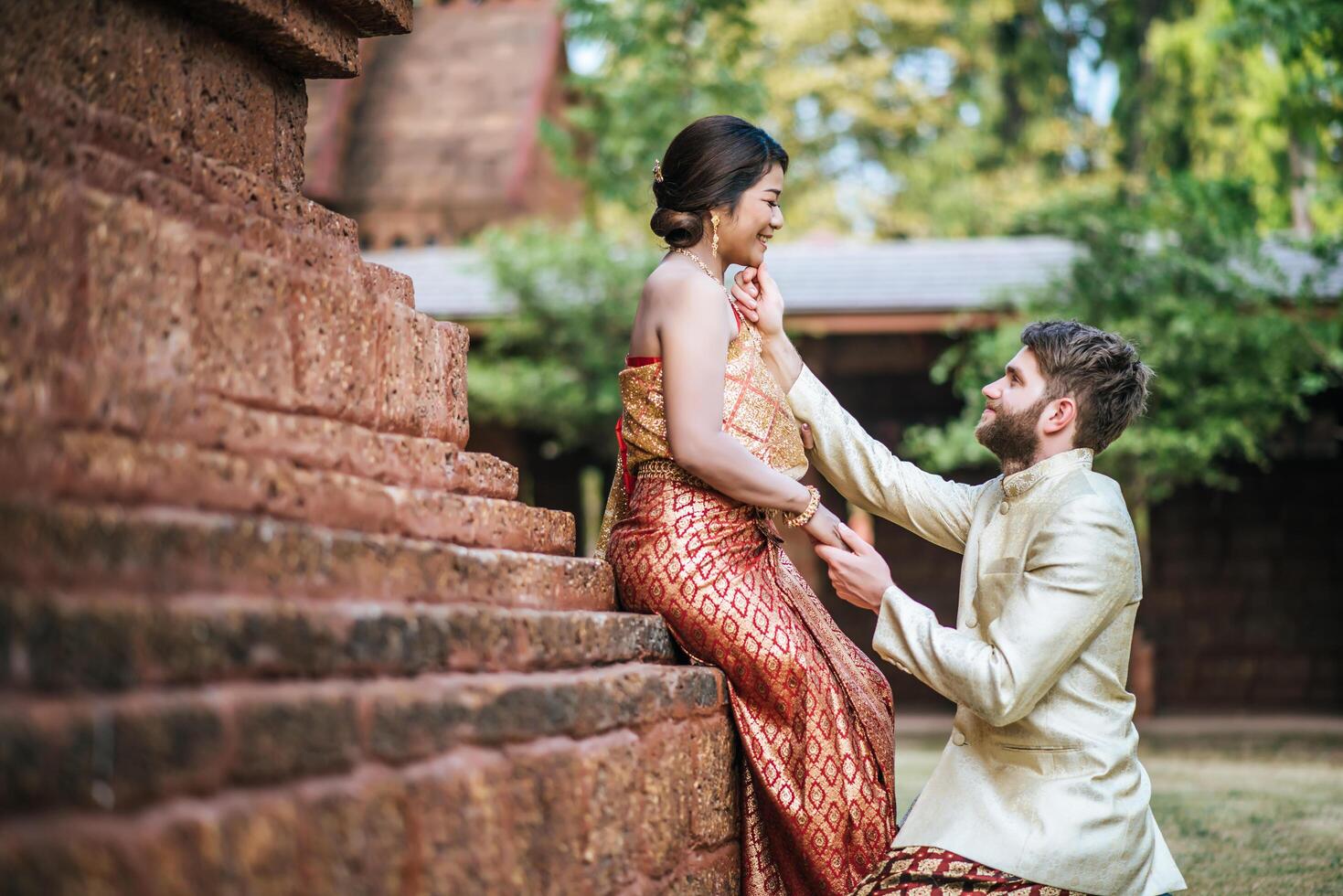 la mariée asiatique et le marié caucasien passent un moment romantique avec une robe thaïlandaise photo