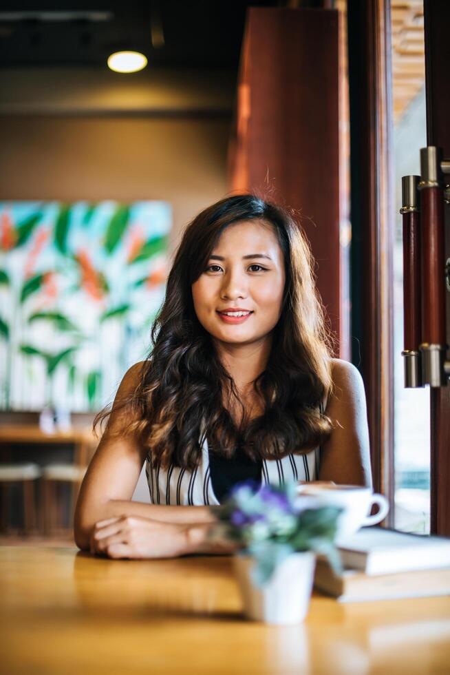 portrait, femme asiatique, sourire, se détendre, dans, café-restaurant, café photo