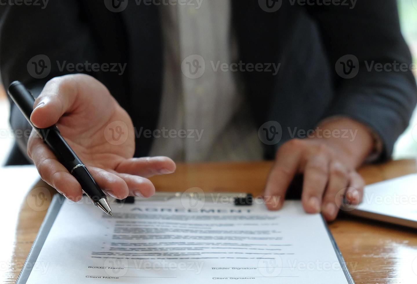 hommes d'affaires vendant la maison indiquant la signature du contrat de vente au bureau. photo