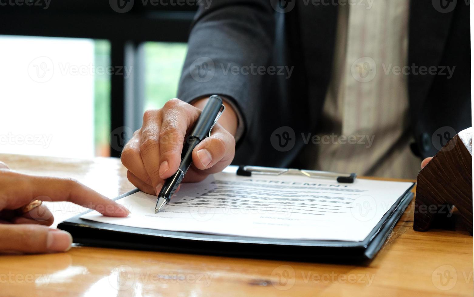 hommes d'affaires vendant la maison indiquant la signature du contrat de vente au bureau. photo