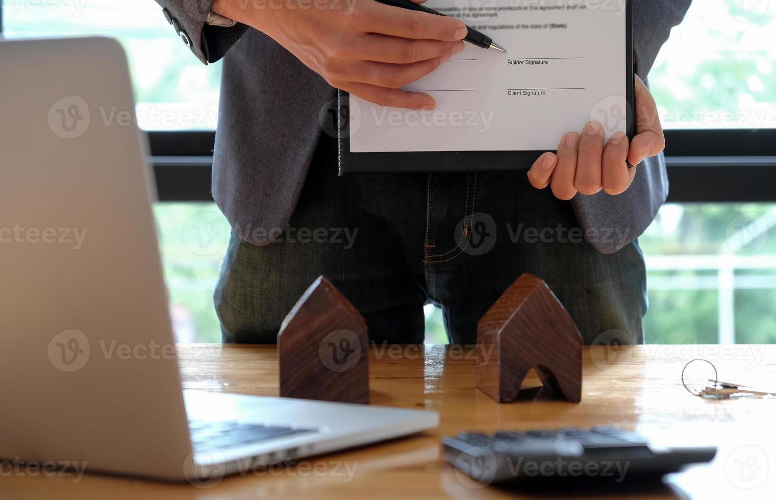 hommes d'affaires vendant la maison indiquant la signature du contrat de vente au bureau. photo