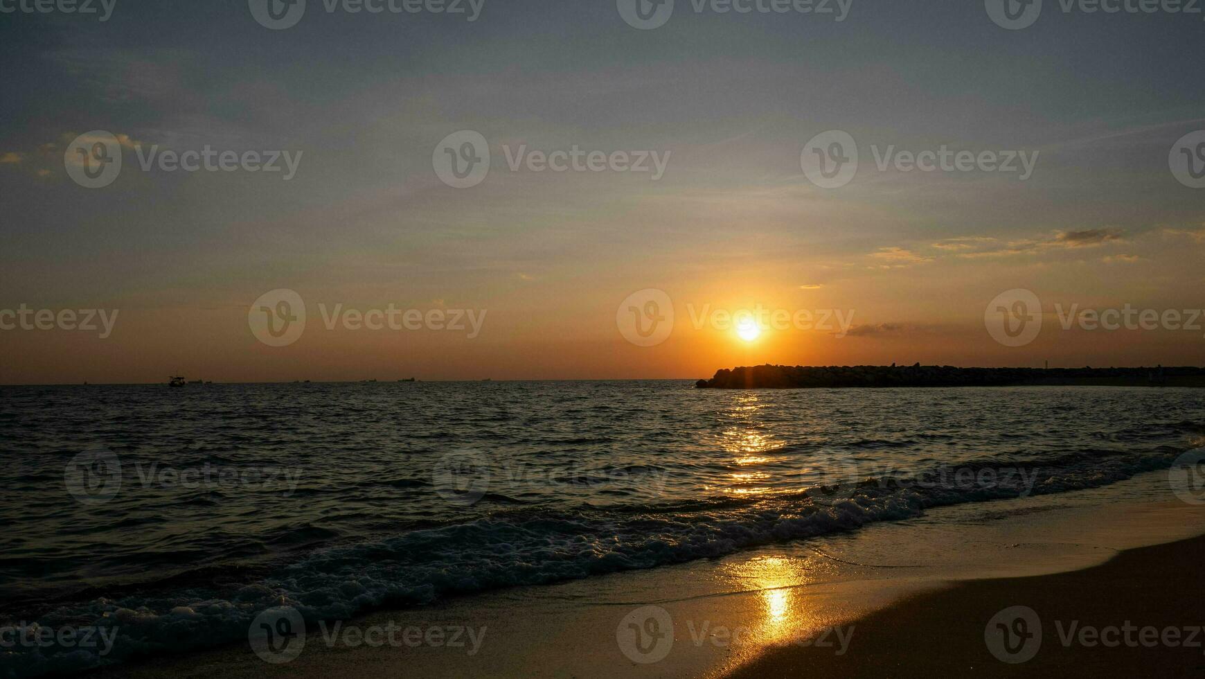 le coucher du soleil sur le mer avec une longue plage photo