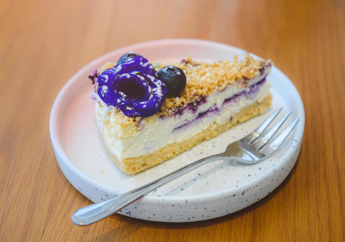 morceau de gâteau au fromage aux baies bleues dans le plat blanc. photo