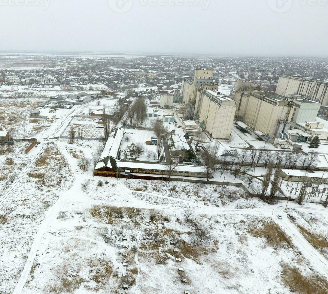 saupoudré avec neige grain ascenseur. hiver vue de le vieux soviétique ascenseur. hiver vue de le des oiseaux œil vue de le village. le des rues sont couvert avec neige photo
