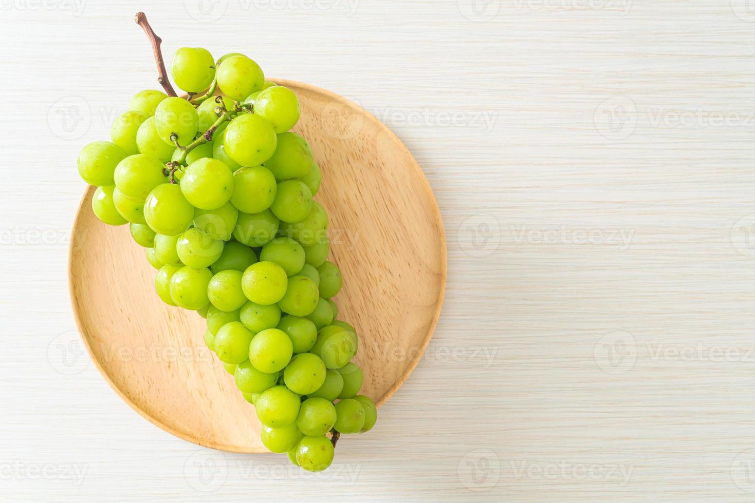 raisin vert frais sur plaque de bois photo