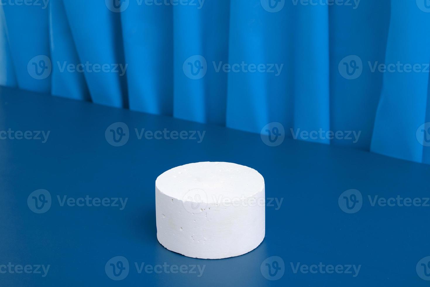 podiums ou maquette de piédestal pour la production cosmétique sur fond bleu avec des plis de tissu. photo