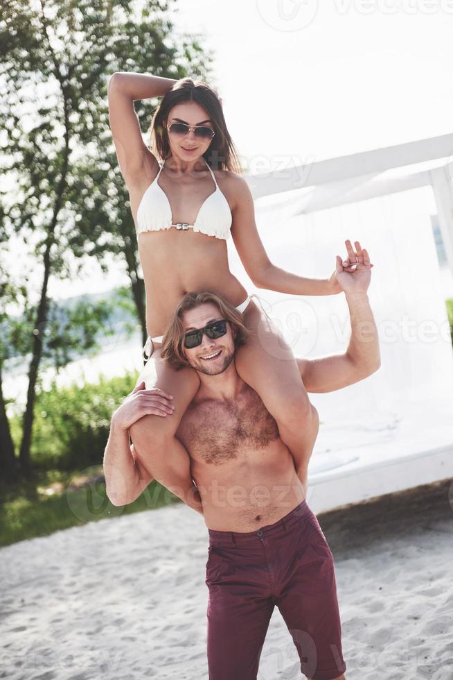 les beaux jeunes en raffolent. un homme tient une femme sur ses épaules, ils sont ludiques et romantiques. photo