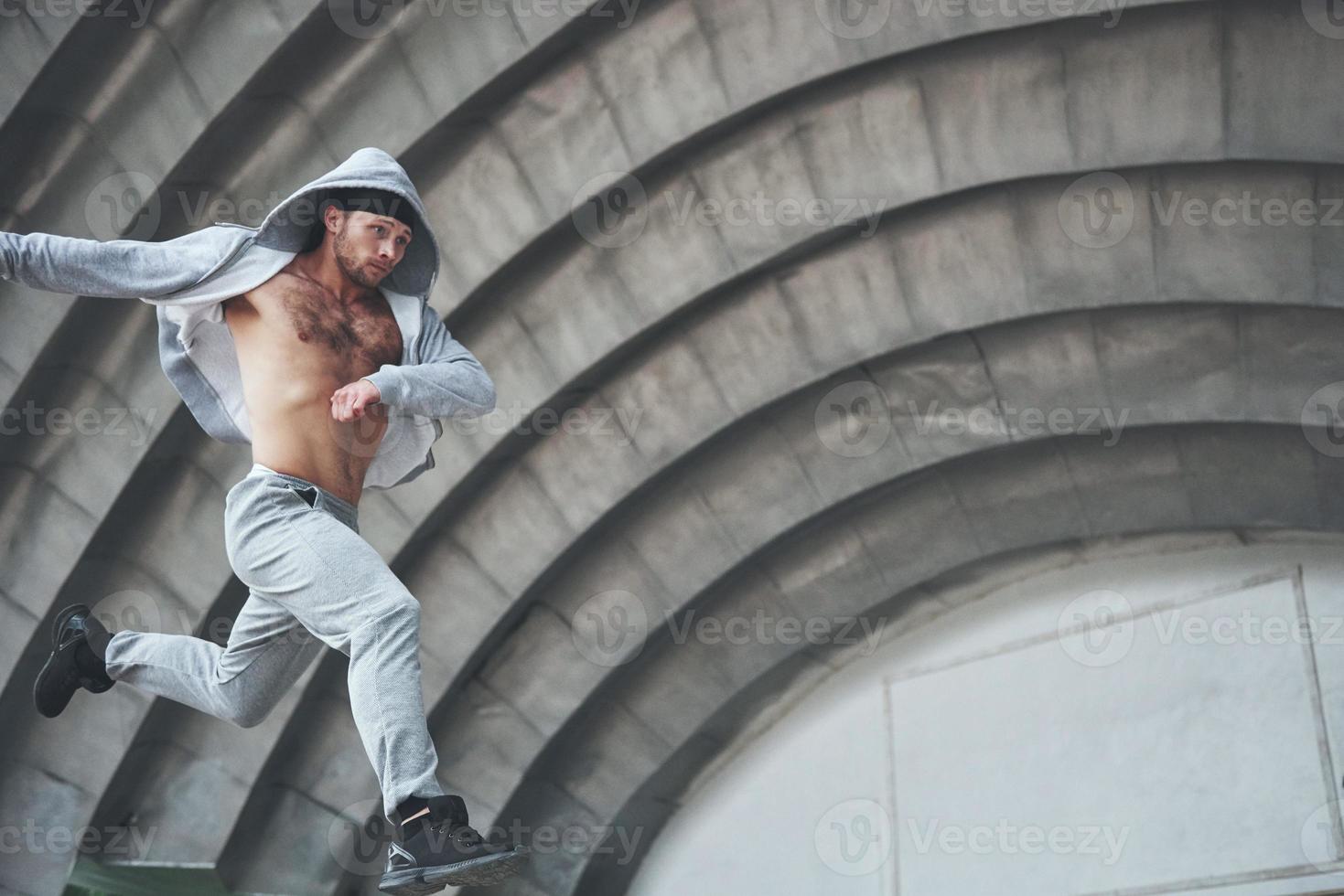 un jeune homme saute. parkour en espace urbain, activité sportive. photo