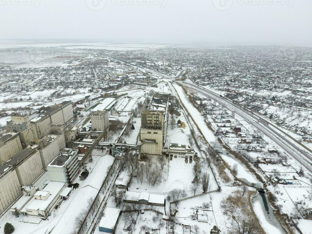 saupoudré avec neige grain ascenseur. hiver vue de le vieux soviétique ascenseur. hiver vue de le des oiseaux œil vue de le village. le des rues sont couvert avec neige photo