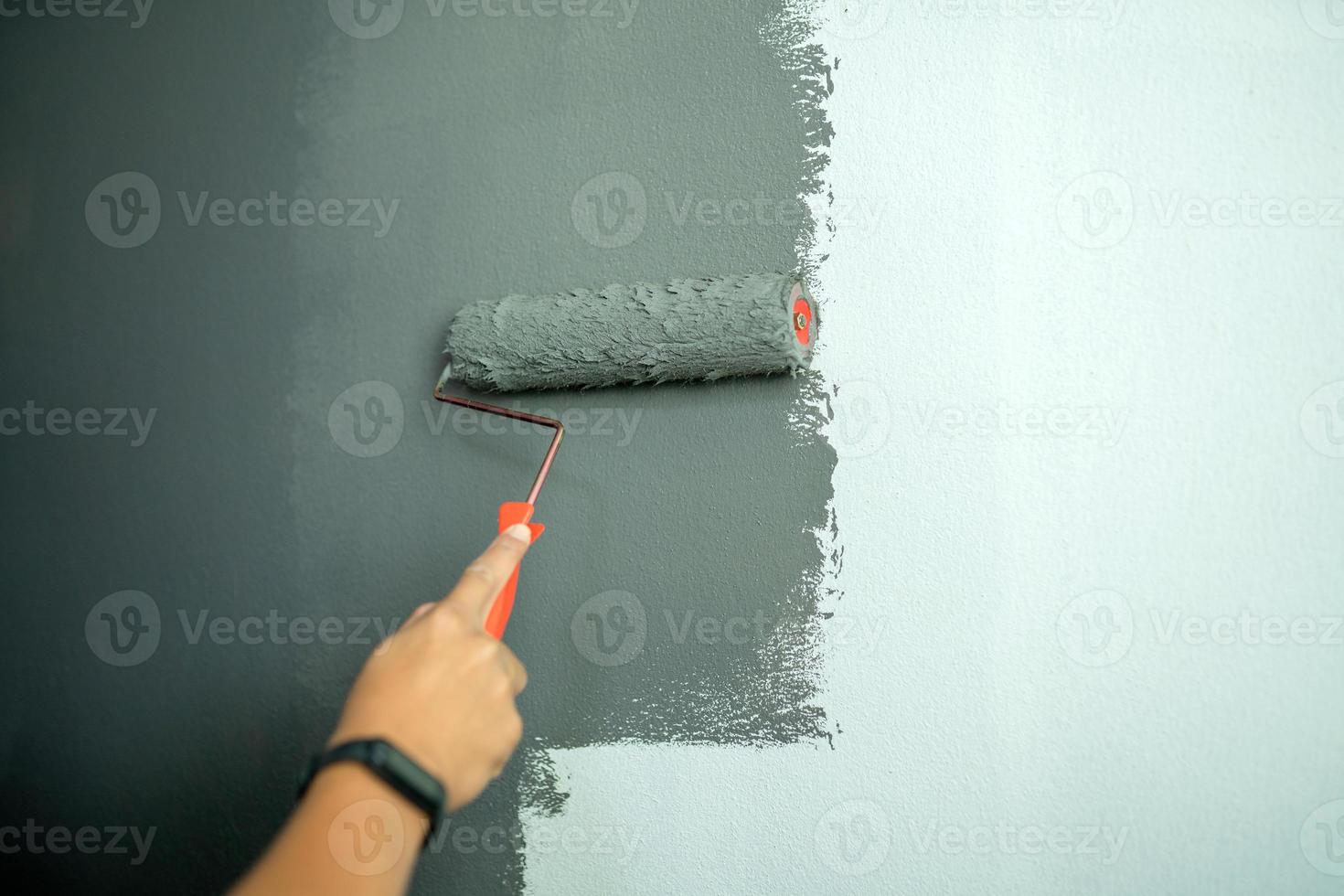 Pièce intérieure de mur de peinture de couleur avec le rouleau de tenue de main photo