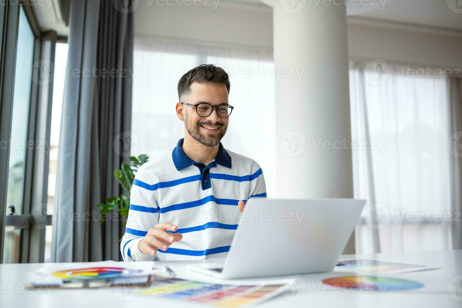 portrait de Masculin intérieur designer travail à Bureau avec Couleur échantillons. homme à lieu de travail choisir coloré échantillons, fermer. Créatif gens concept. photo