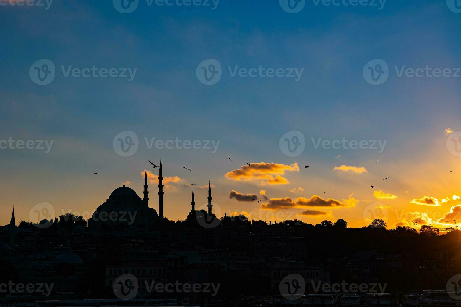 Istanbul silhouette à le coucher du soleil. Suleymaniye mosquée et nuageux ciel photo