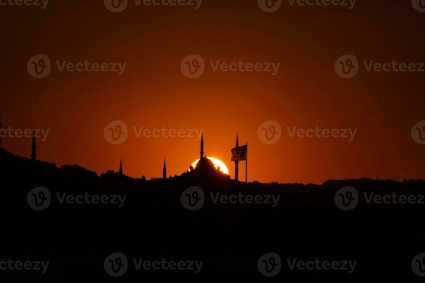 fatih mosquée et drapeau avec Soleil à le coucher du soleil. silhouette de Istanbul photo