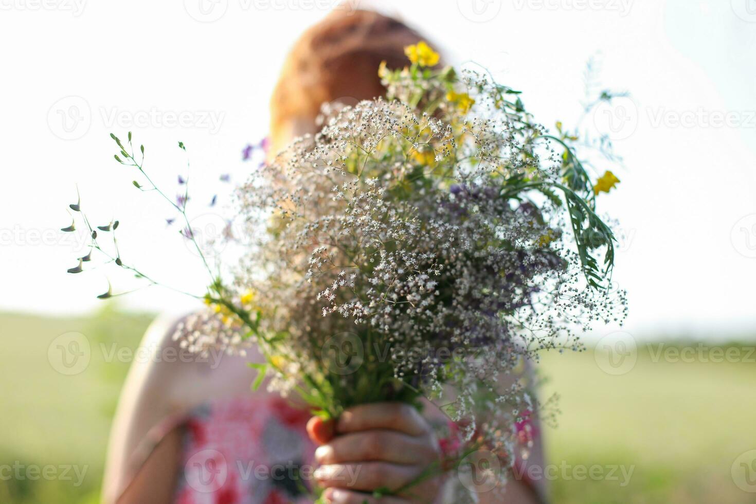 portrait de une roux fille avec une bouquet de fleurs sauvages photo