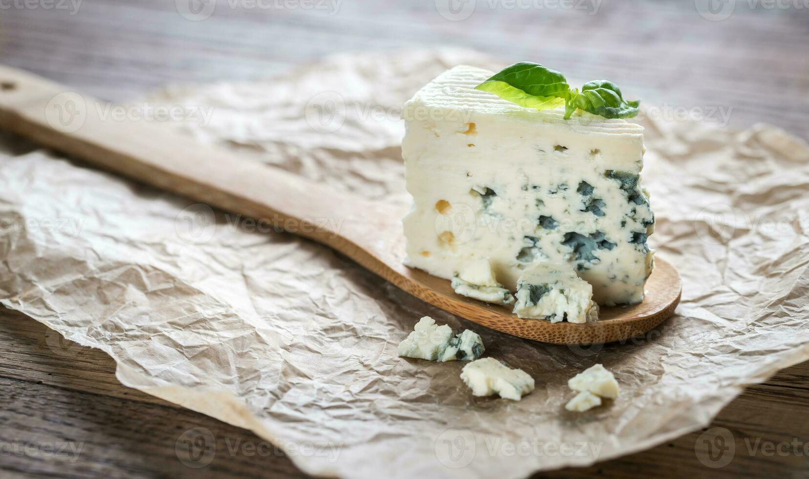 pièce de le bleu fromage sur le en bois cuillère photo