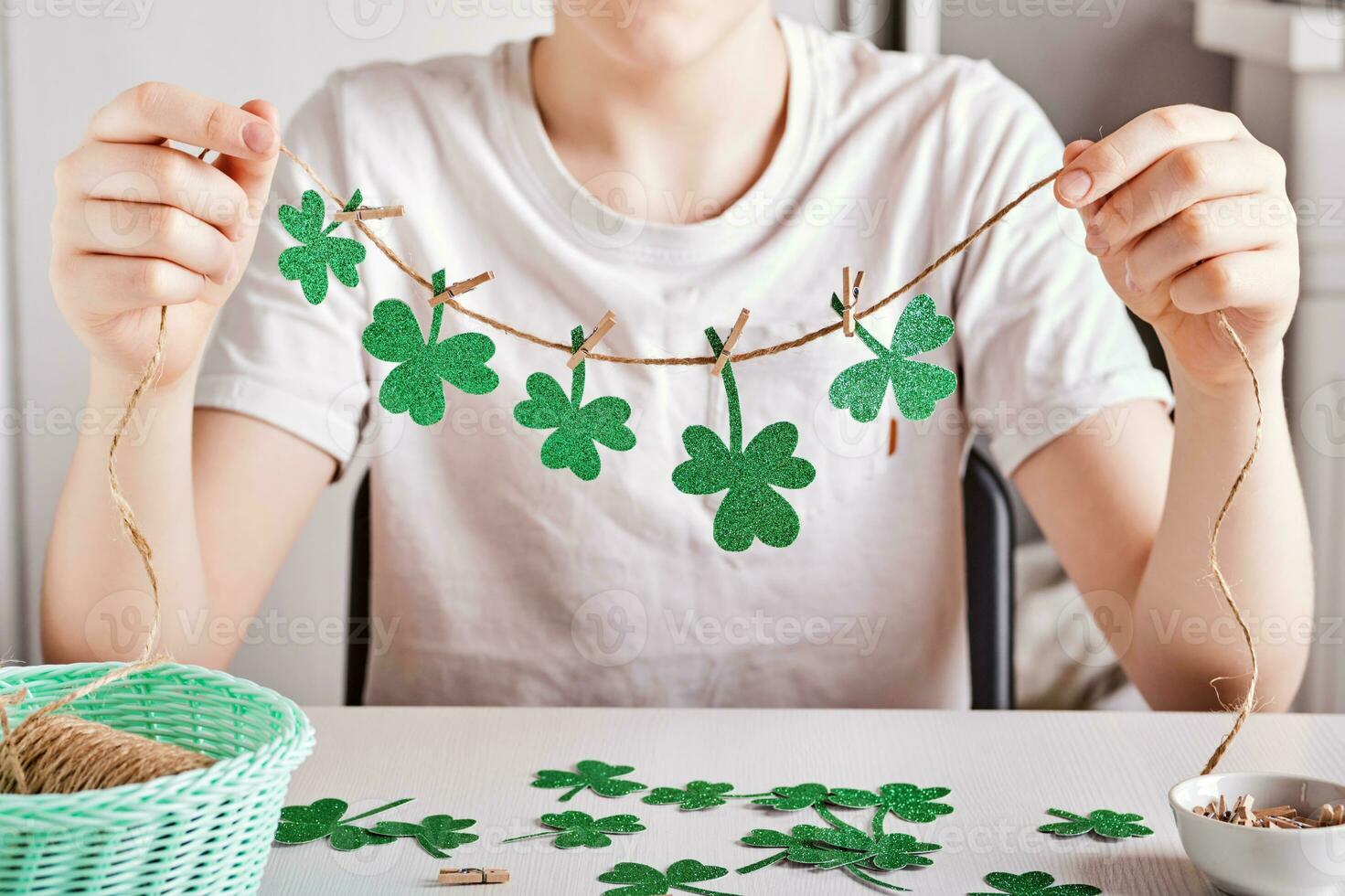 DIY saint patrick journée décor. content garçon faire guirlande de brillant vert papier. sélectif concentrer photo