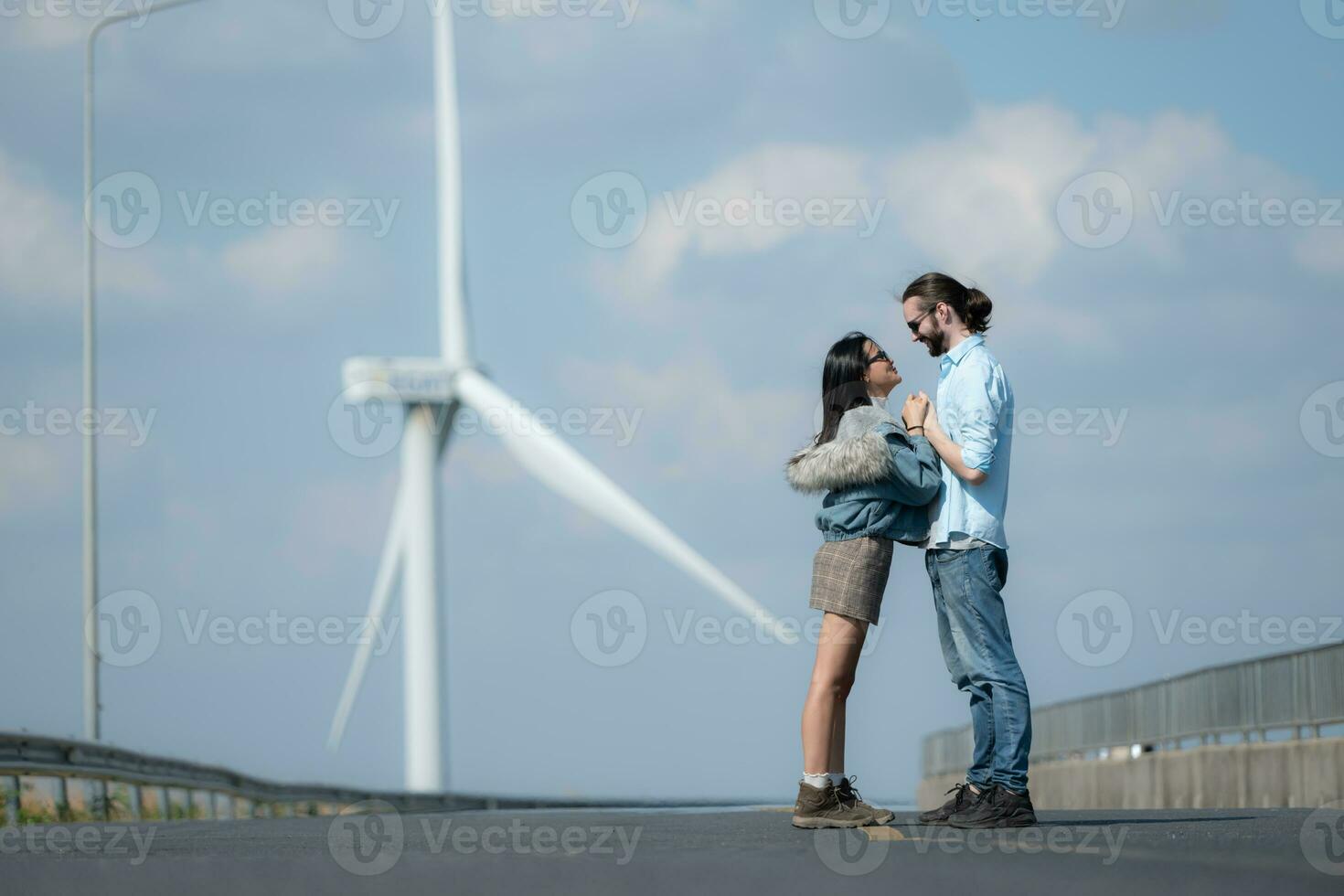 sur le route, une Jeune couple propose à chaque autre, avec vent turbines dans le Contexte. photo