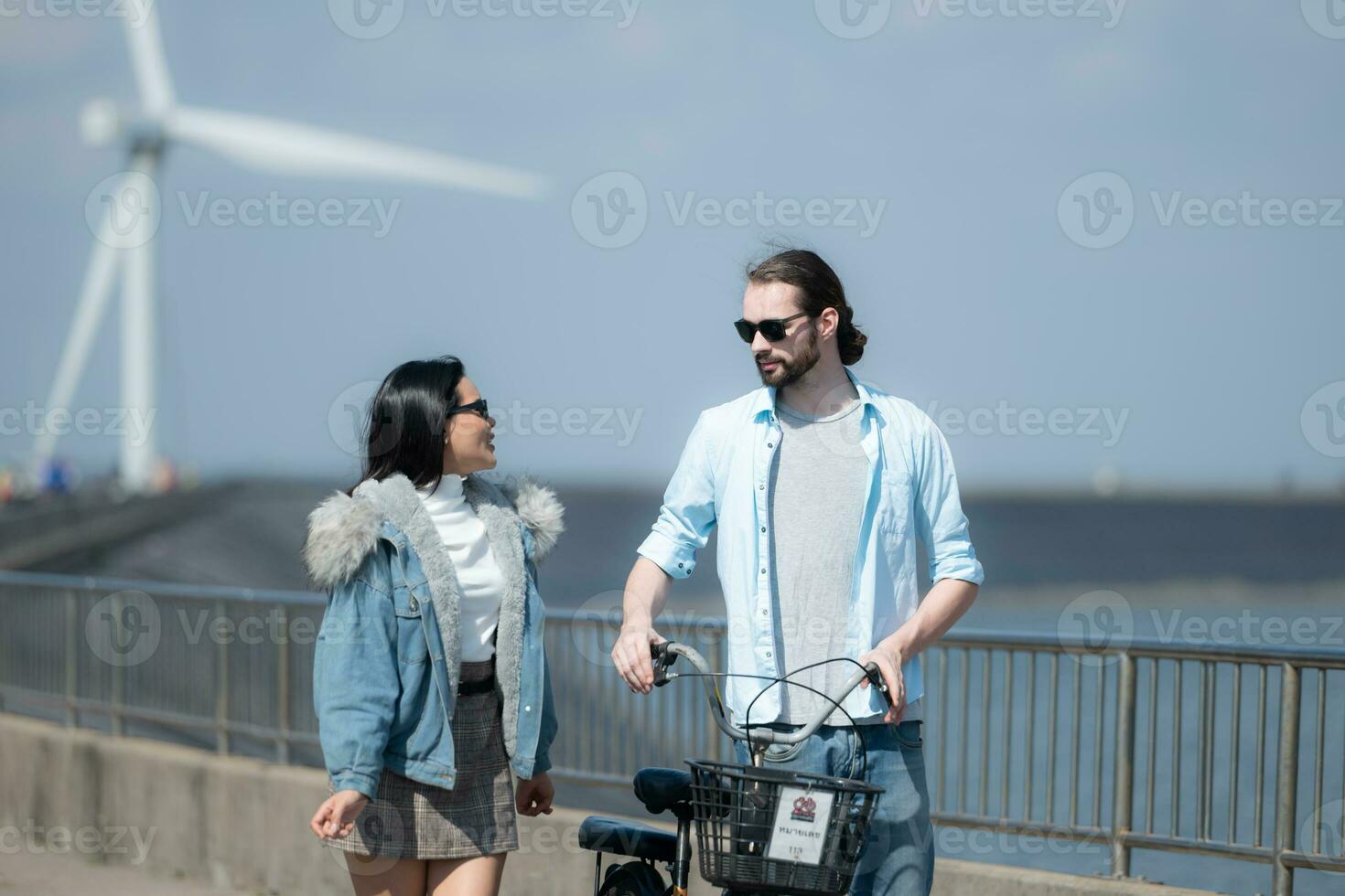 Jeune couple relaxant par le vent turbine sur le Lac photo