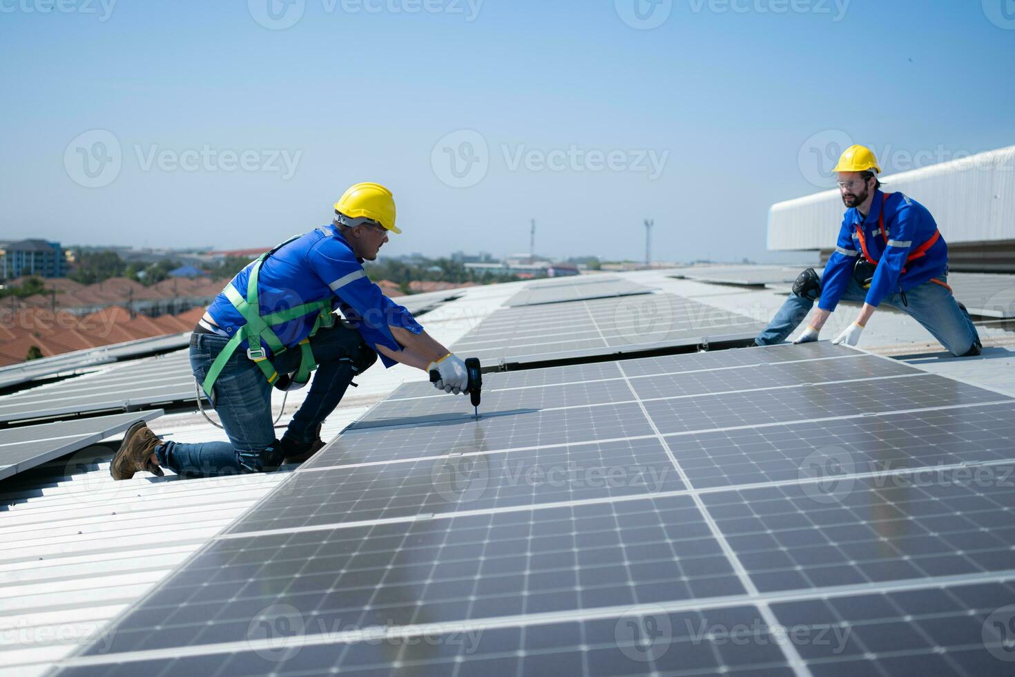 tous les deux de techniciens est installation solaire panneaux sur le toit de le entrepôt à changement solaire énergie dans électrique énergie pour utilisation dans des usines. photo