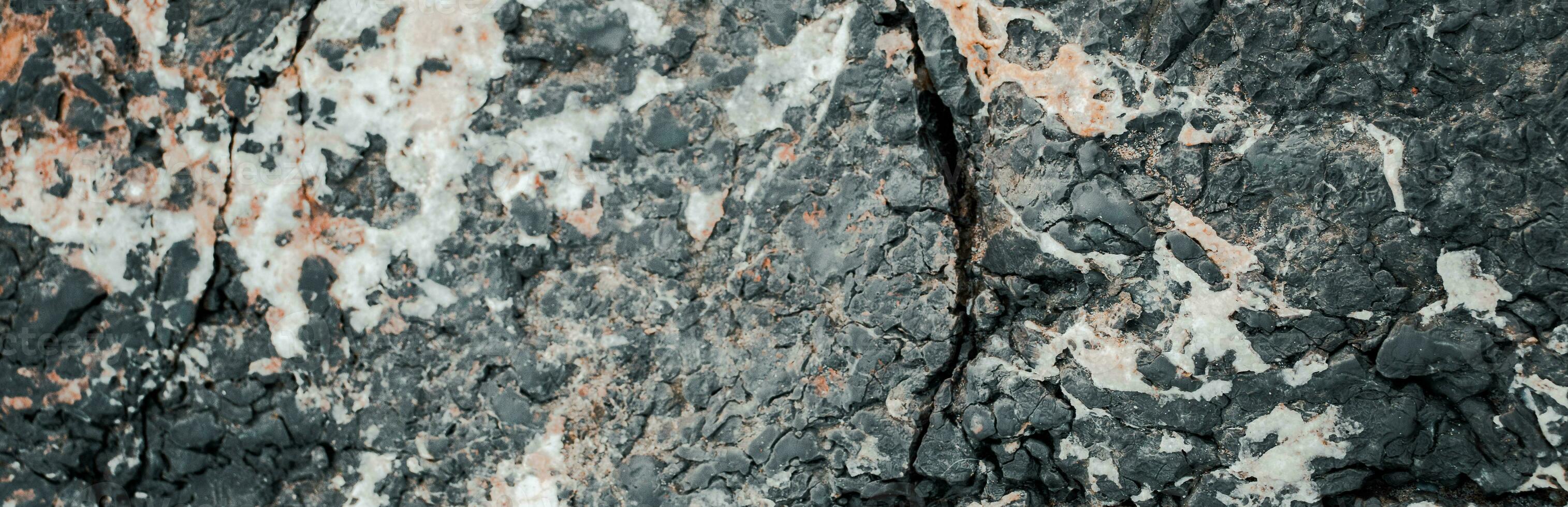 le surface de le Montagne pierre mur photo. Roche texture. gris grunge Contexte près bord de mer. photo