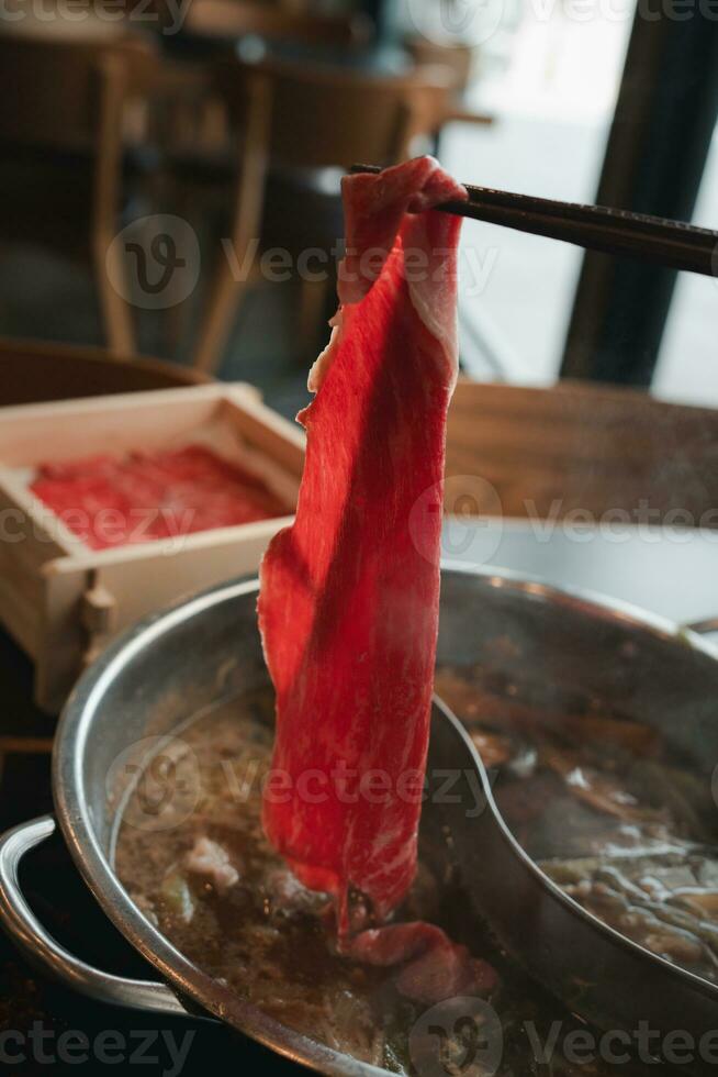 homme en portant baguettes avec une pièce de bouilli tranché brut bœuf. photo