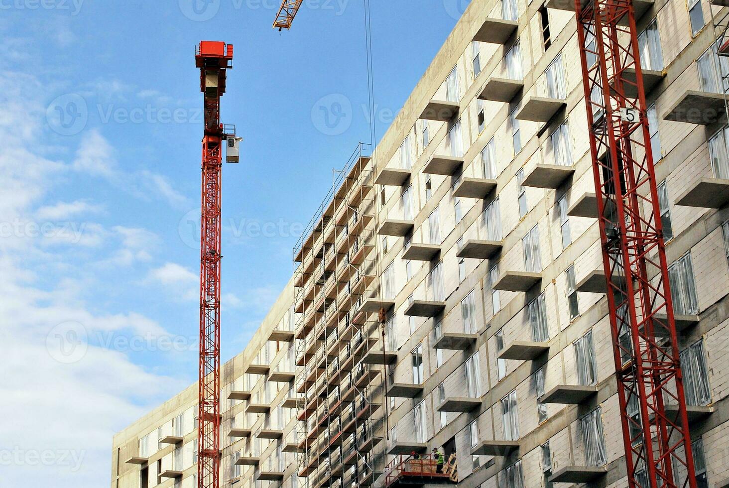 haute monter bâtiment en dessous de construction. installation de verre façade panneaux sur une renforcé béton structure. photo