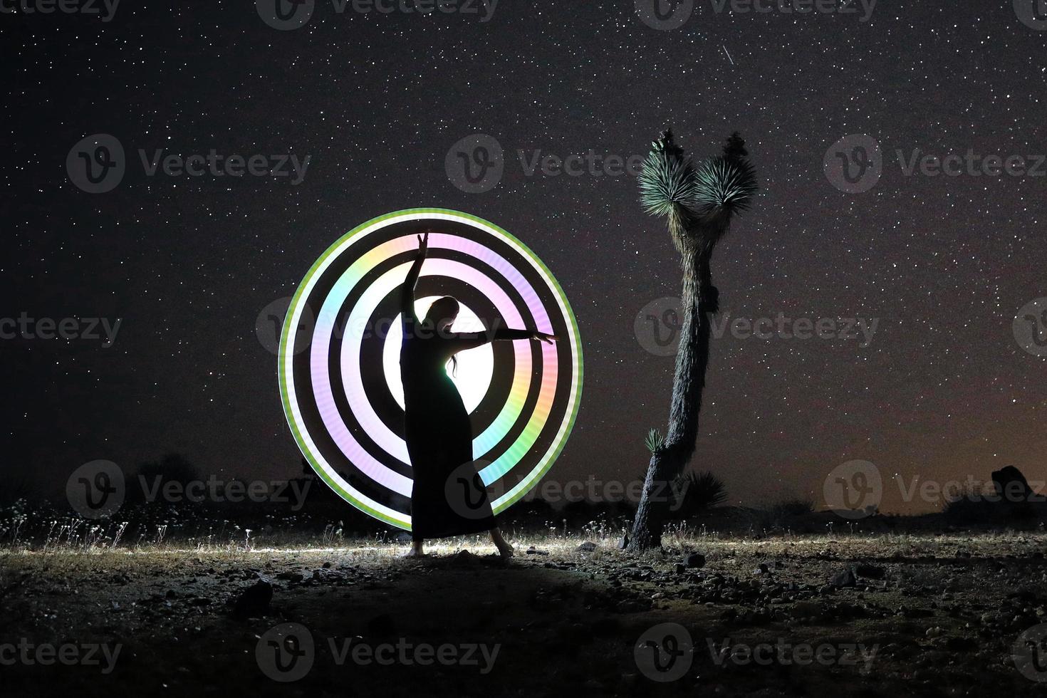 personne lumière peinte dans le désert sous le ciel nocturne photo