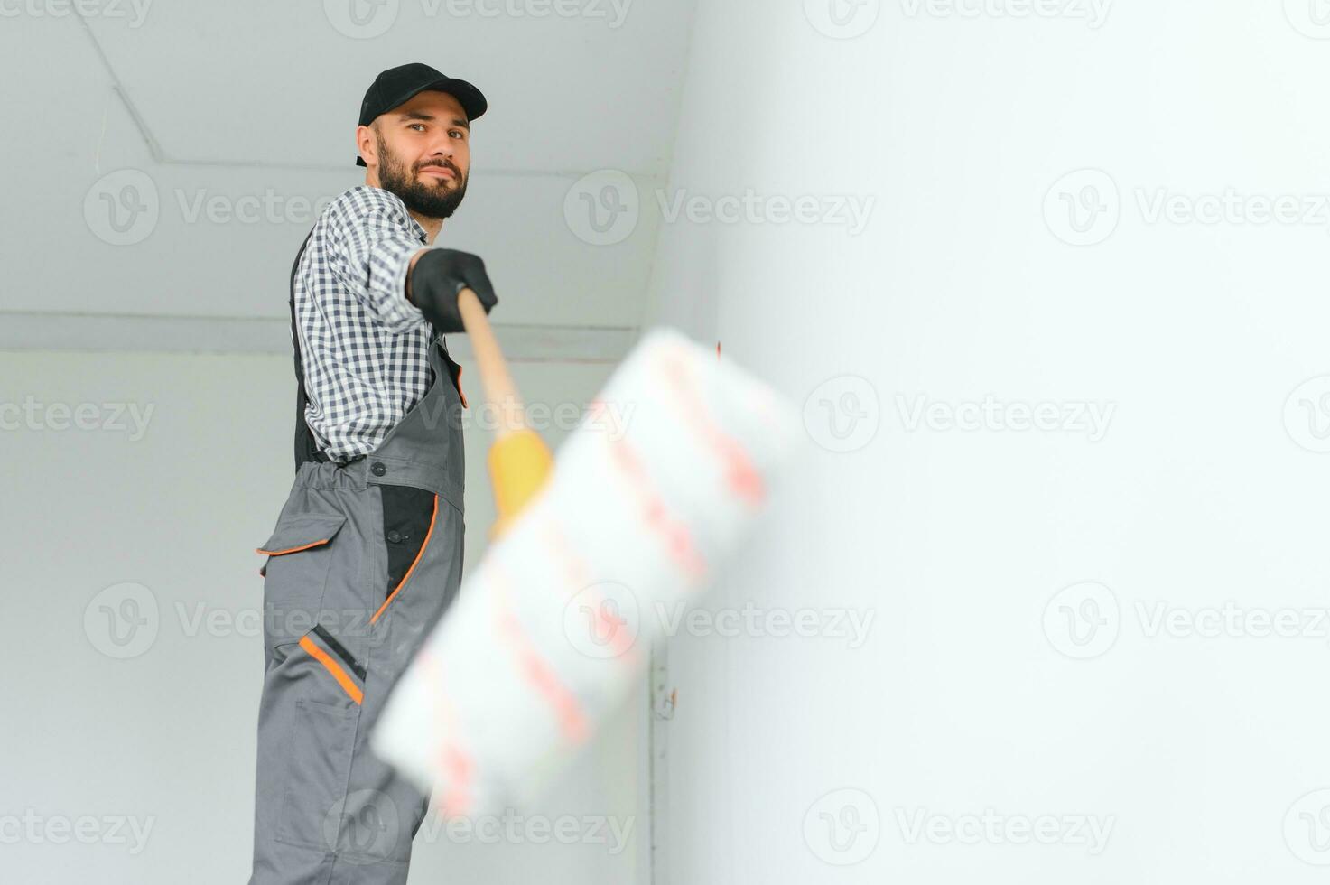 Jeune ouvrier La peinture mur dans chambre. photo