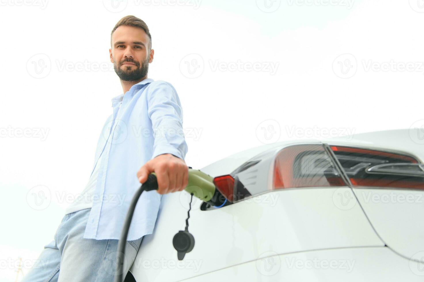 élégant homme inserts prise de courant dans le électrique voiture mise en charge prise photo