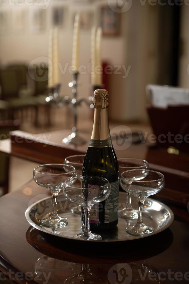 un plateau avec des coupes de champagne et une bouteille de vin mousseux. photo