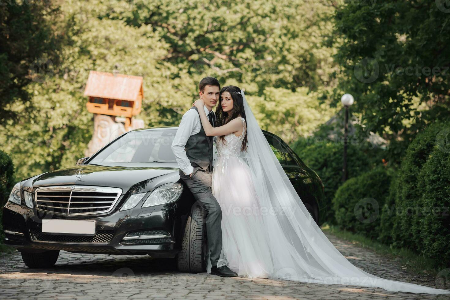 magnifique la mariée avec branché maquillage et coiffure dans luxe mariage robe avec Beau jeune marié près noir mariage voiture photo