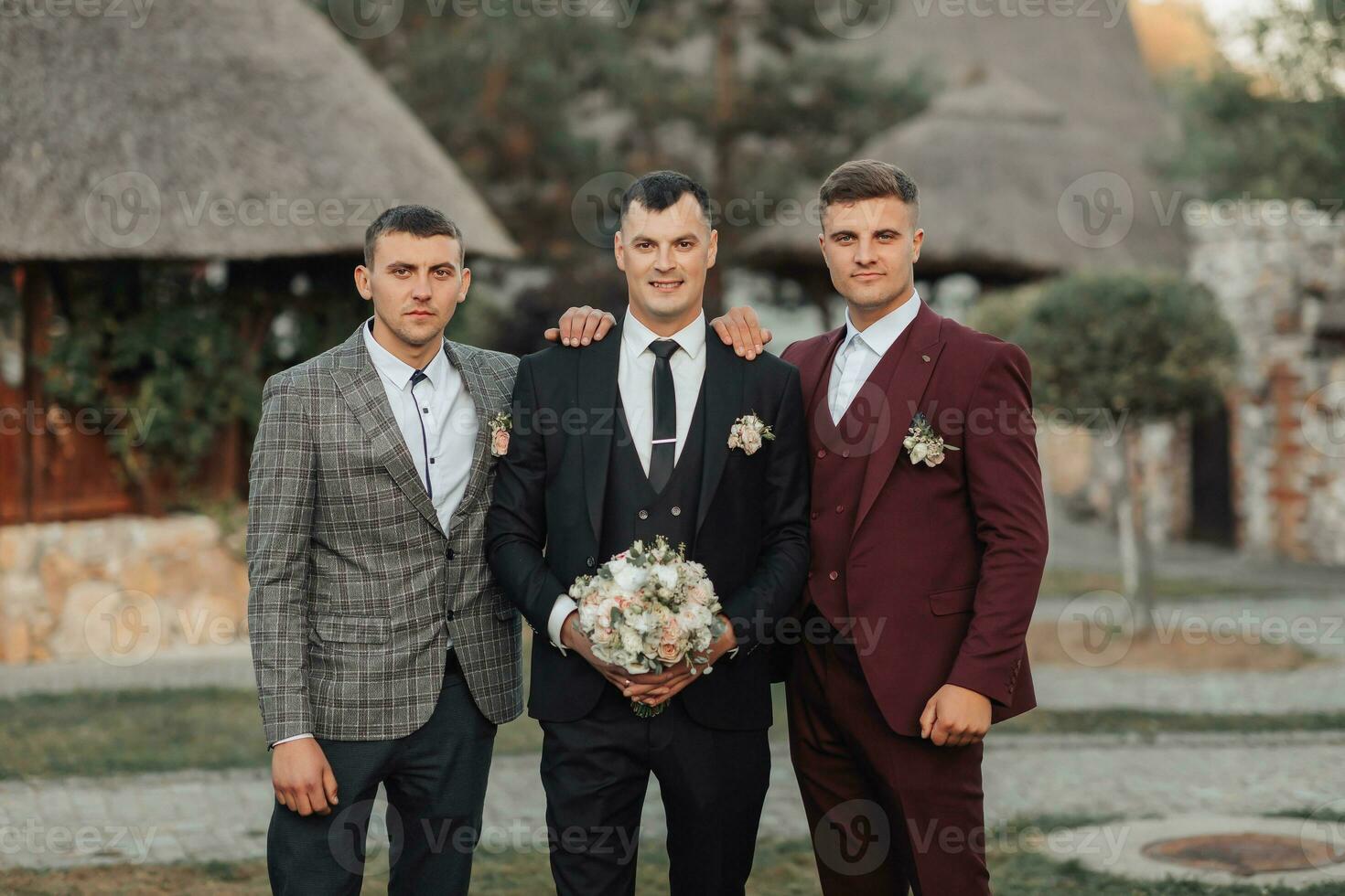 photo de Trois Hommes dans classique combinaisons. une homme détient une bouquet tandis que permanent parmi le sien amis. affaires style. élégant Hommes