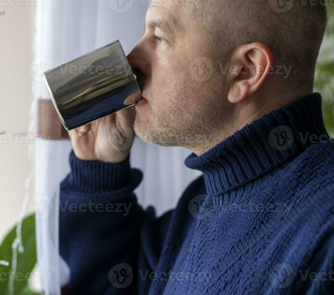 portrait de le milieu vieilli homme avec gris cheveux, portant chaud, foncé bleu chandail, en buvant café. gens photo